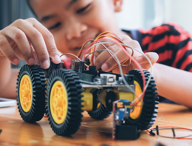 Boy building a robotic car