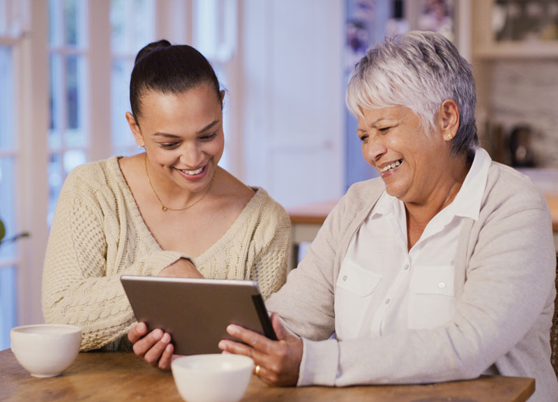 Woman and her mom looking at a tablet
