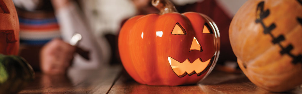 Pumpkins next to a candle on a table