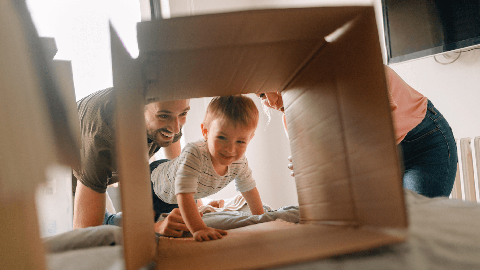 Family playing with a cardboard box.