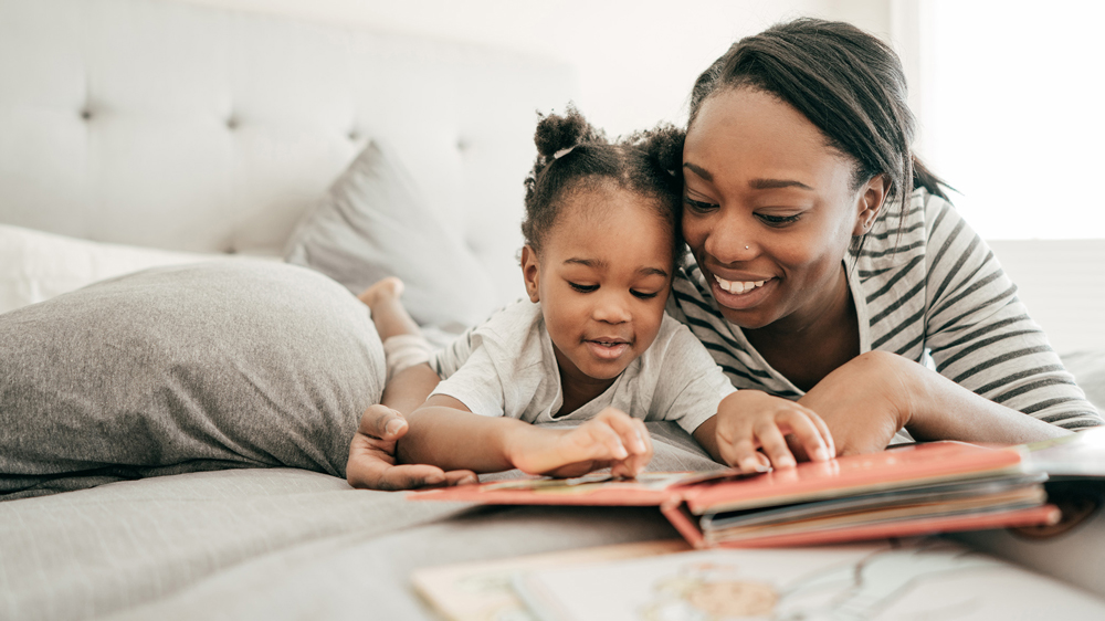 A mother and daughter reading a book.