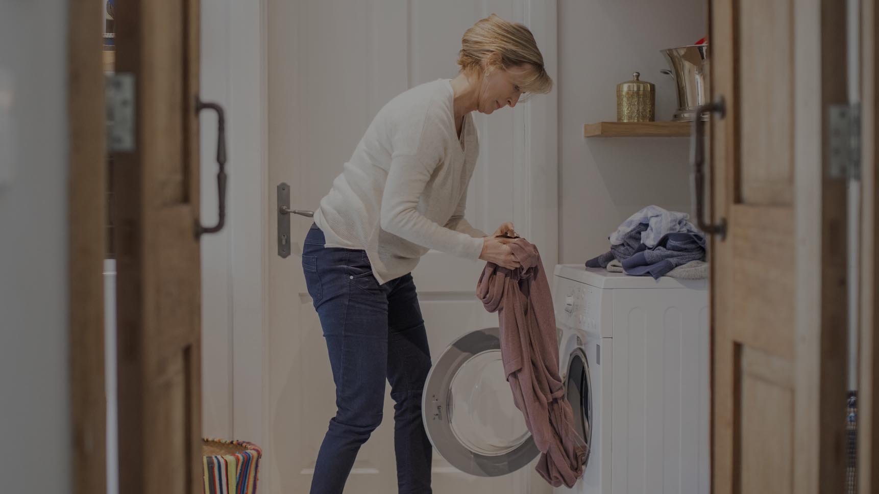 Woman pulling laundry out of washer