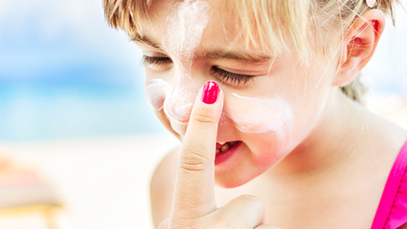 Girl getting sunscreen applied