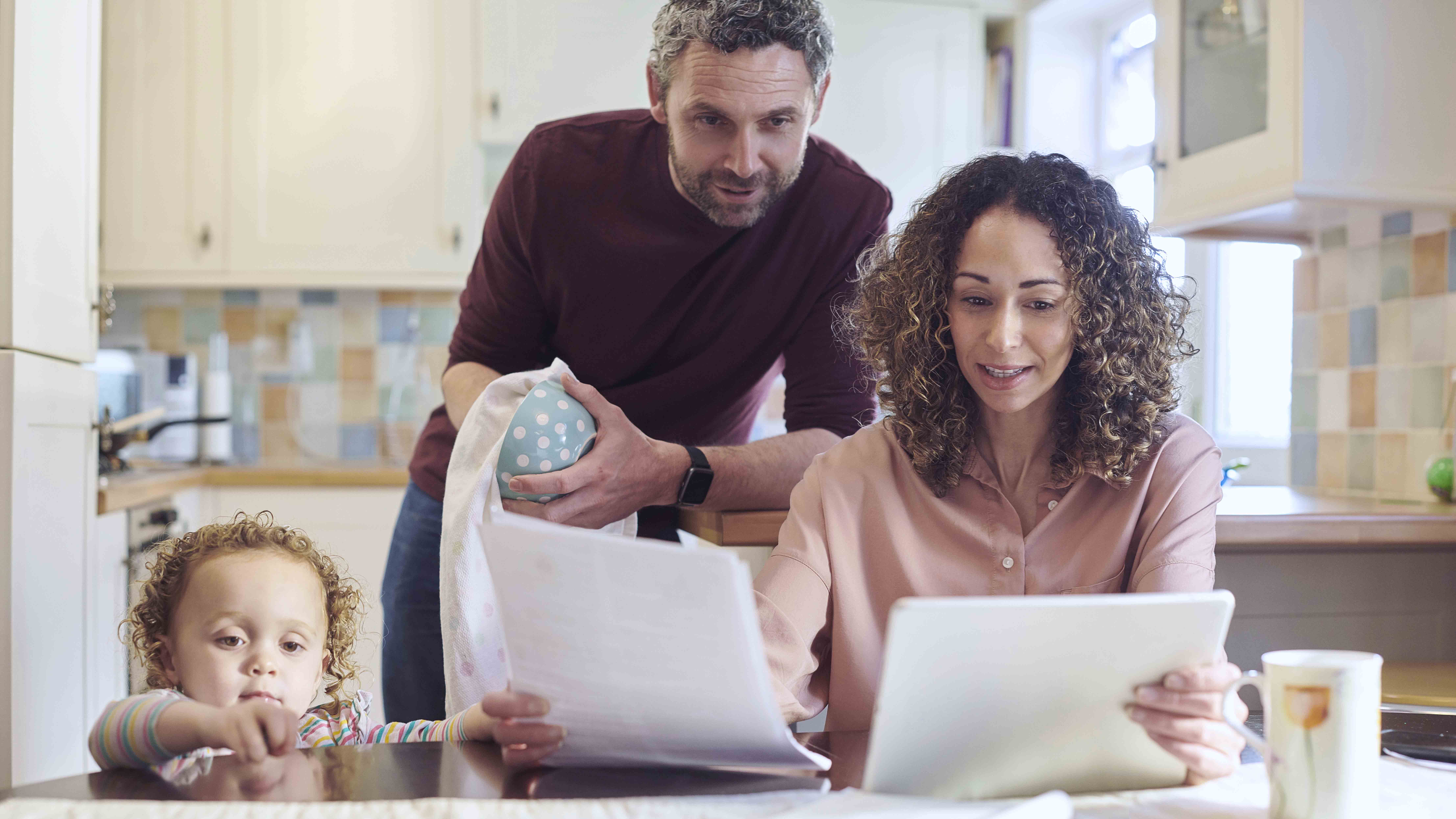 Family sitting at a table looking at papers.