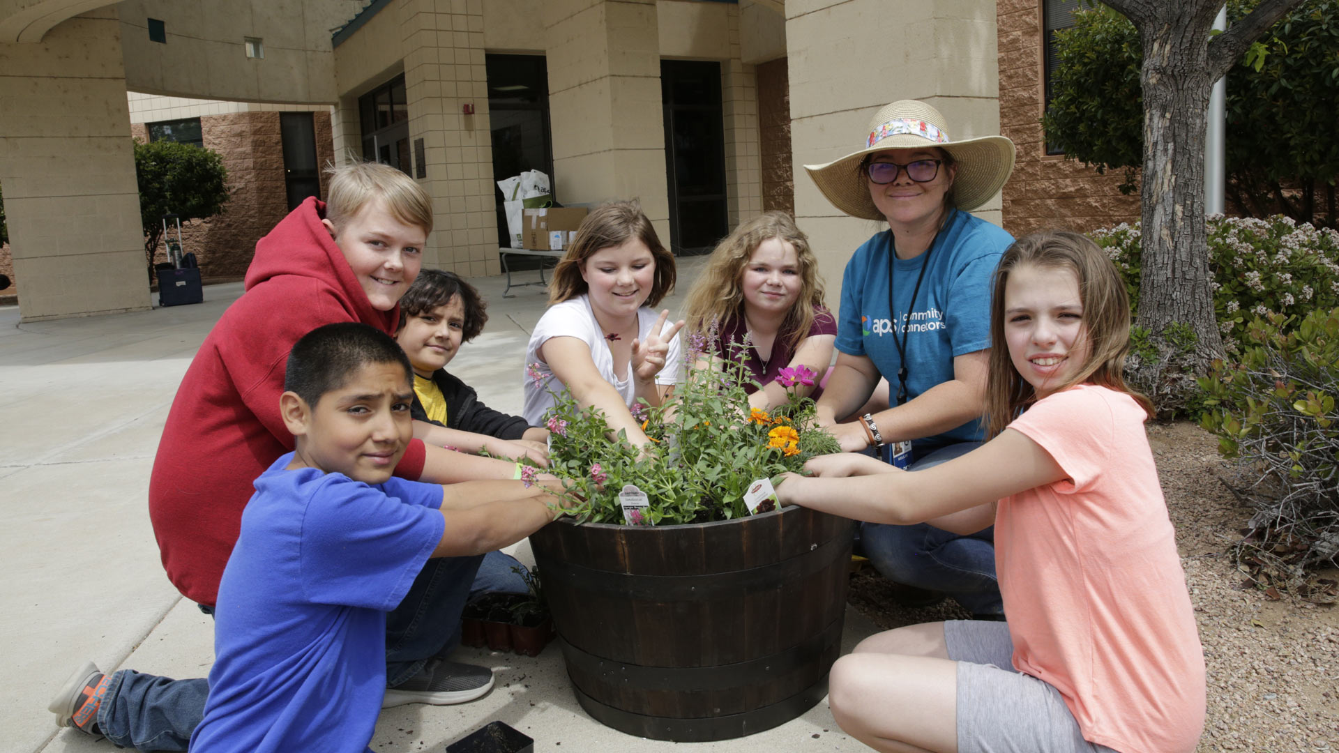 APS volunteer planting flowers with school kids