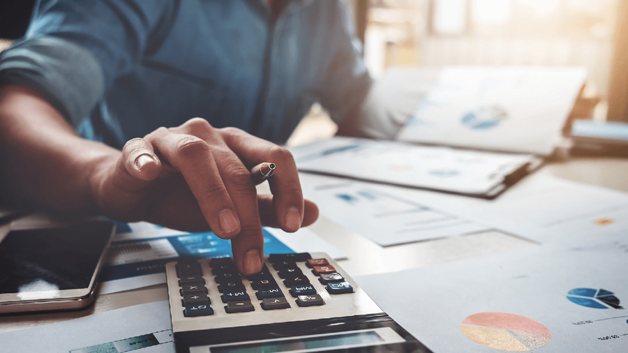 Man using a calculator and looking at paperwork.