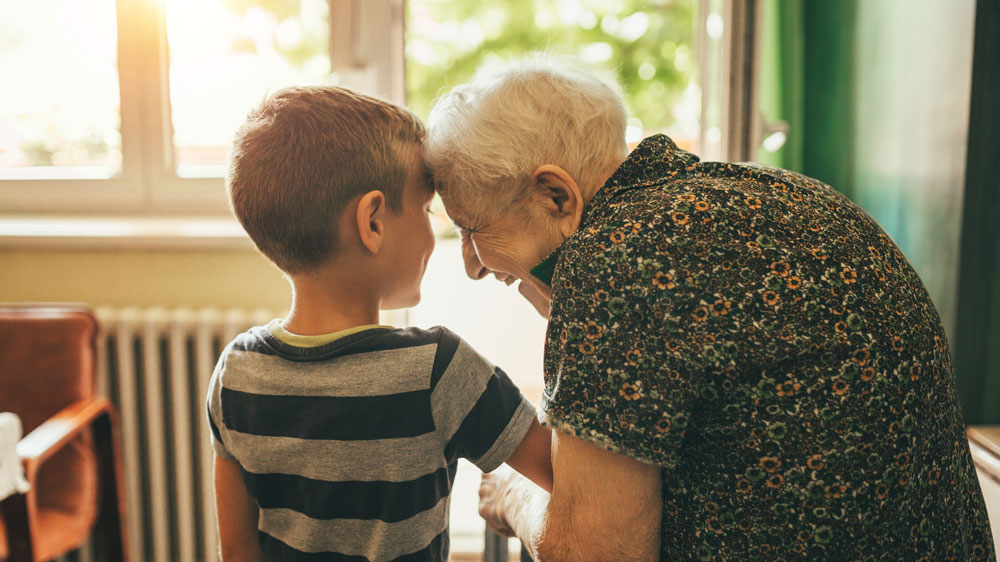 Grandmother with her grandson at a sunny window.