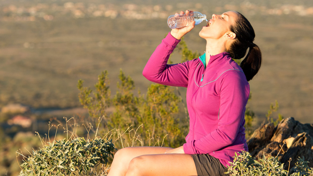 Hiker drinkng water on the trail