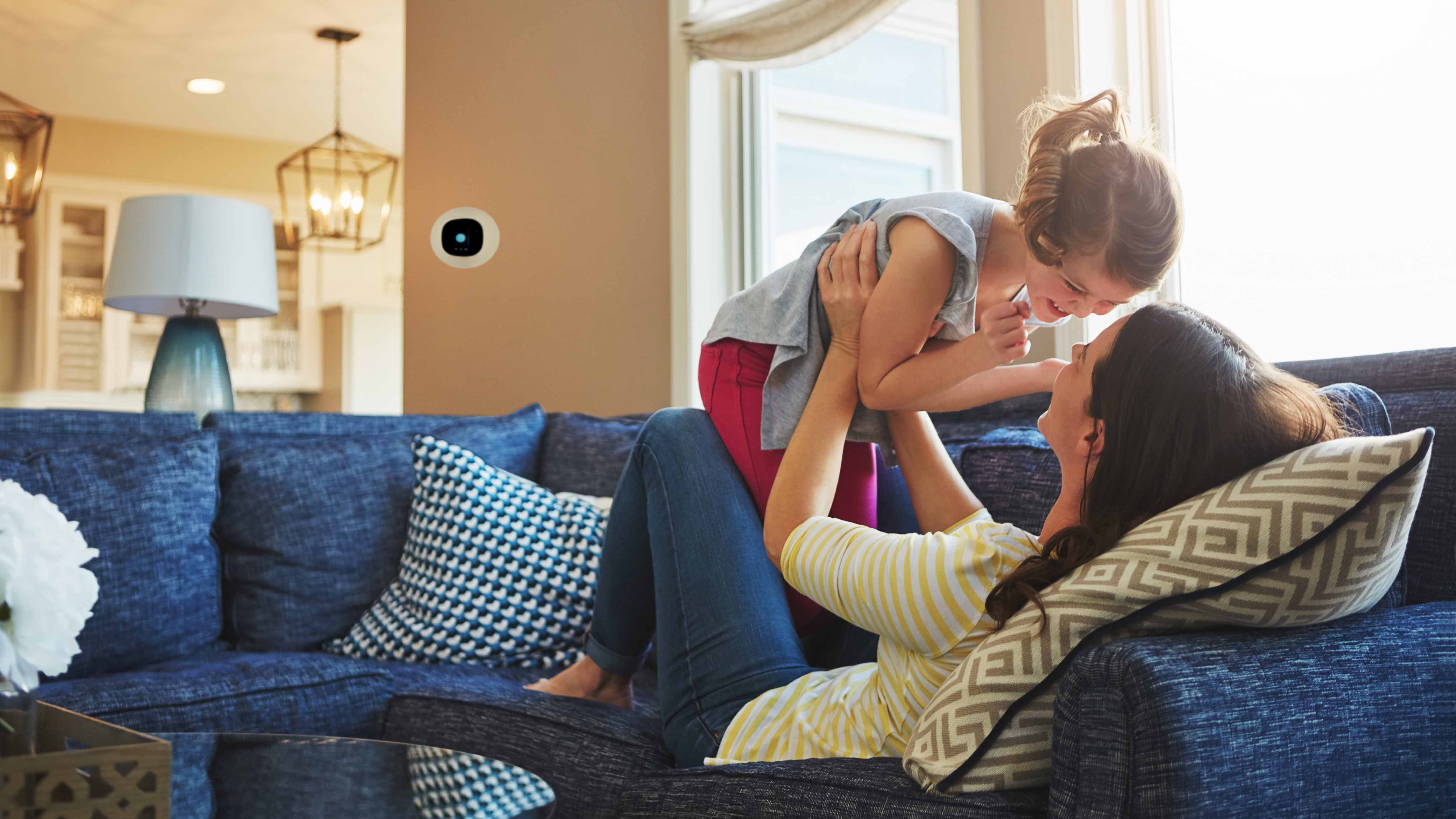 Mother lifting child on couch