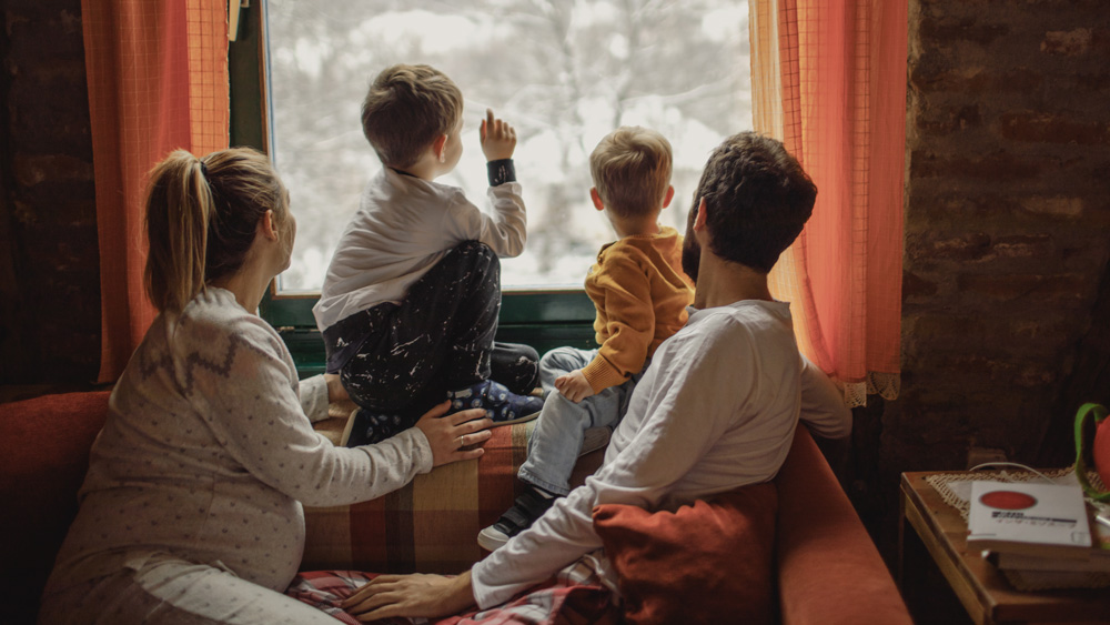 Family looking out the window in the winter