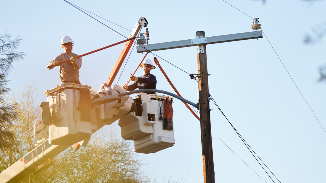 Linemen in a boom truck working on a line
