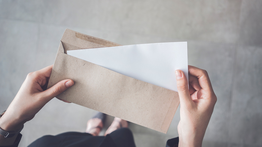 Woman taking a piece of paper out of an envelope. 