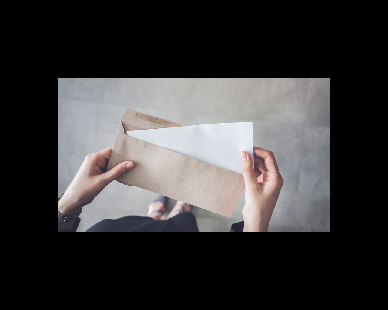 Woman taking a piece of paper out of an envelope. 