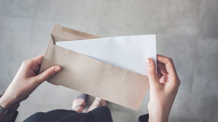 Woman taking a piece of paper out of an envelope.