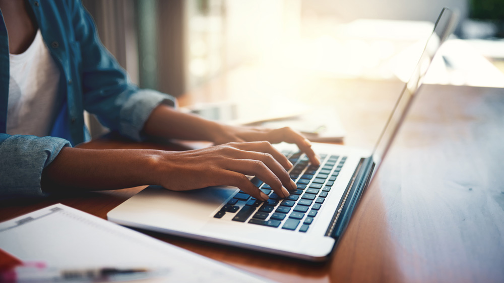 Woman typing on a laptop.